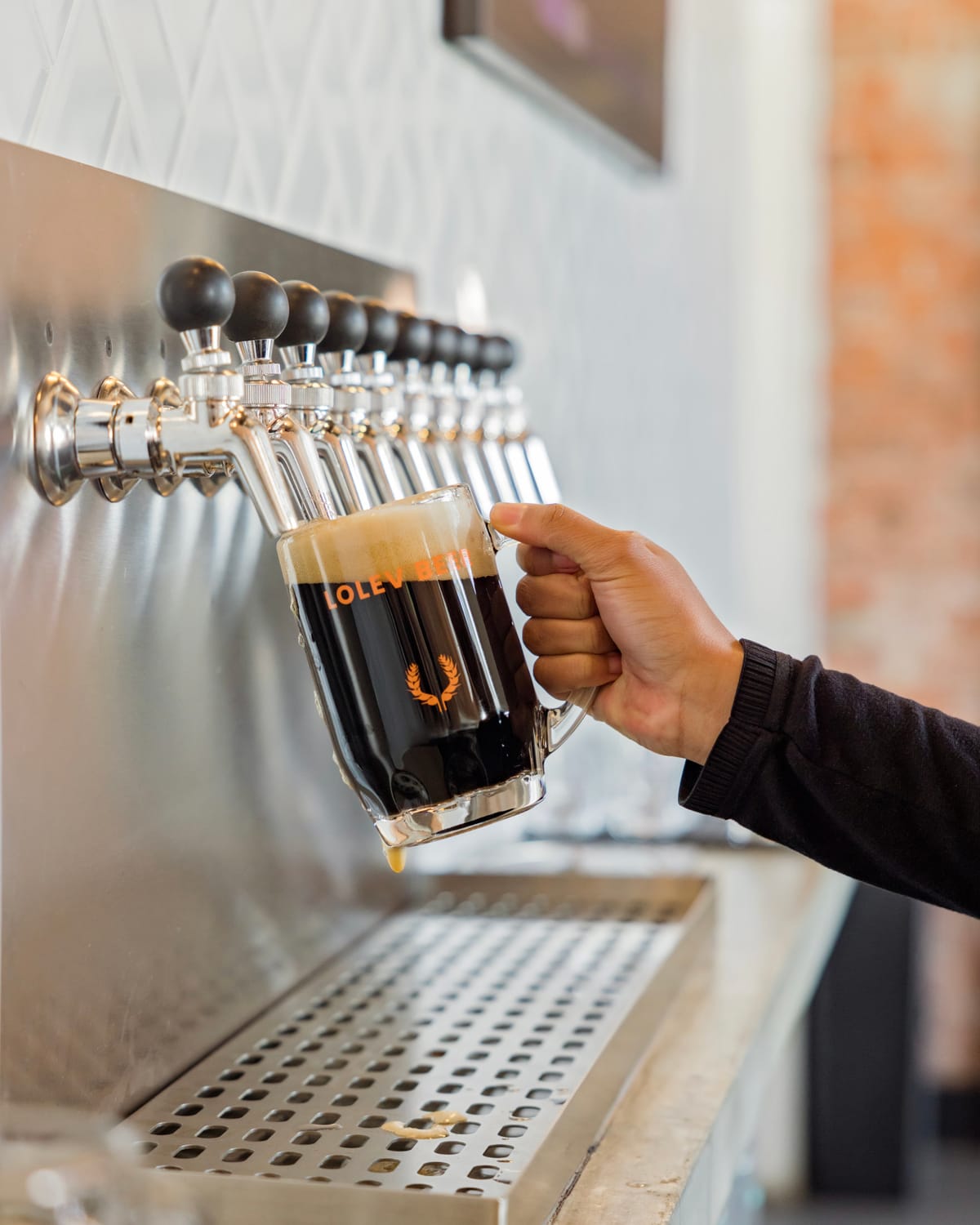 Draft beer poured from a row of taps
