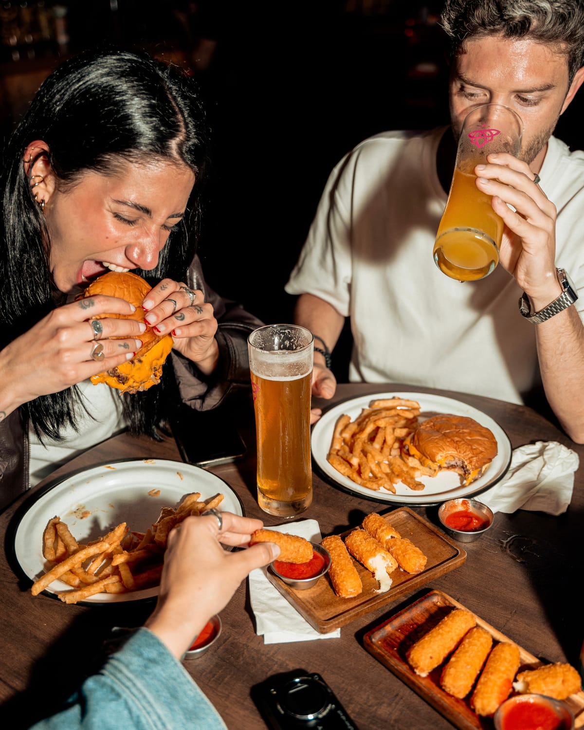 Friends sharing burgers and beers at a table