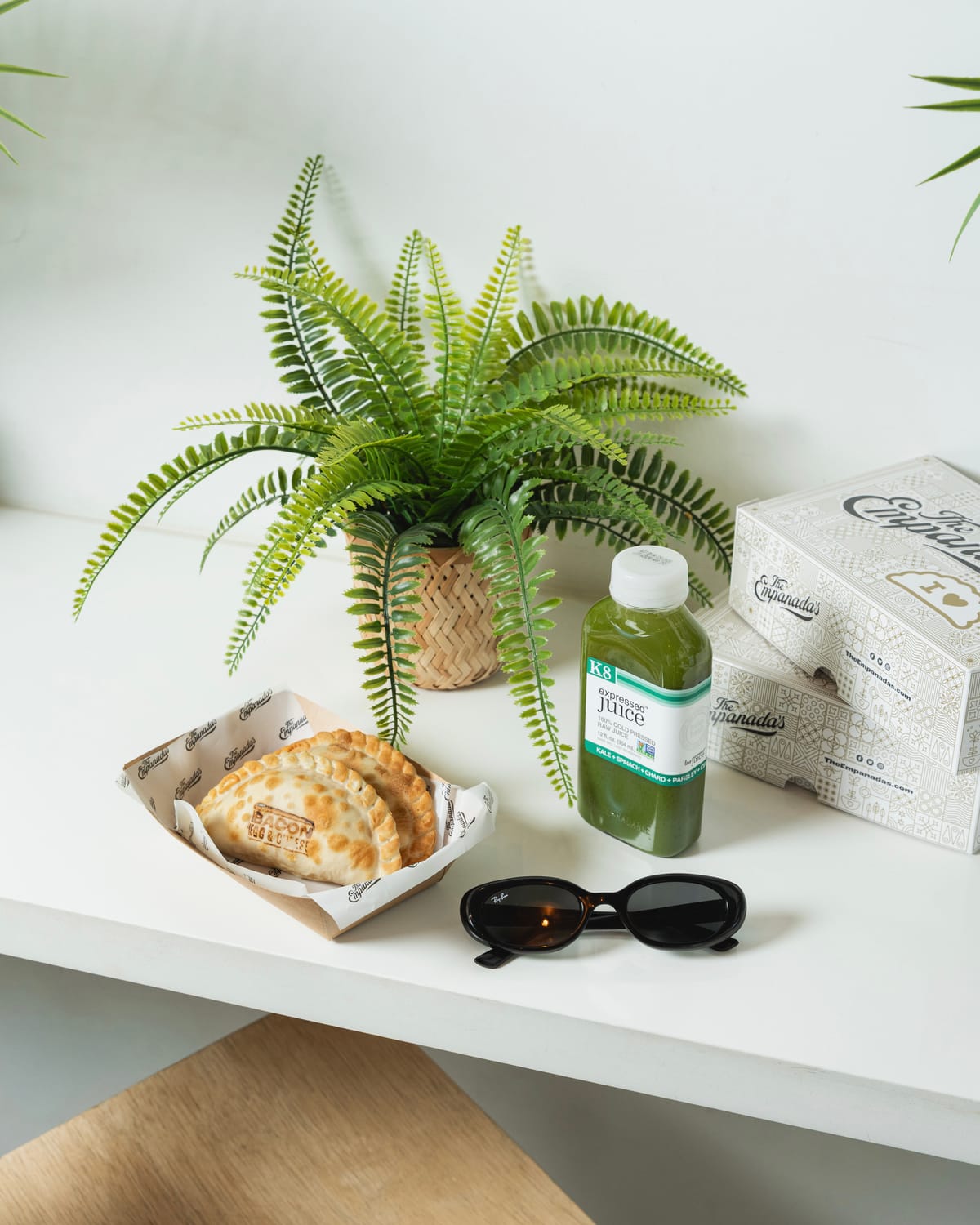 Product flat lay with packaging, plants and cold-pressed juice