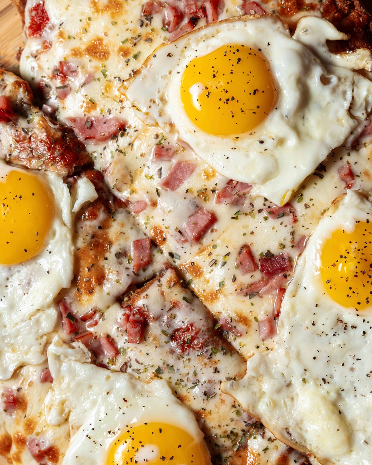 Pizza topped with fried eggs and bacon, shot close up